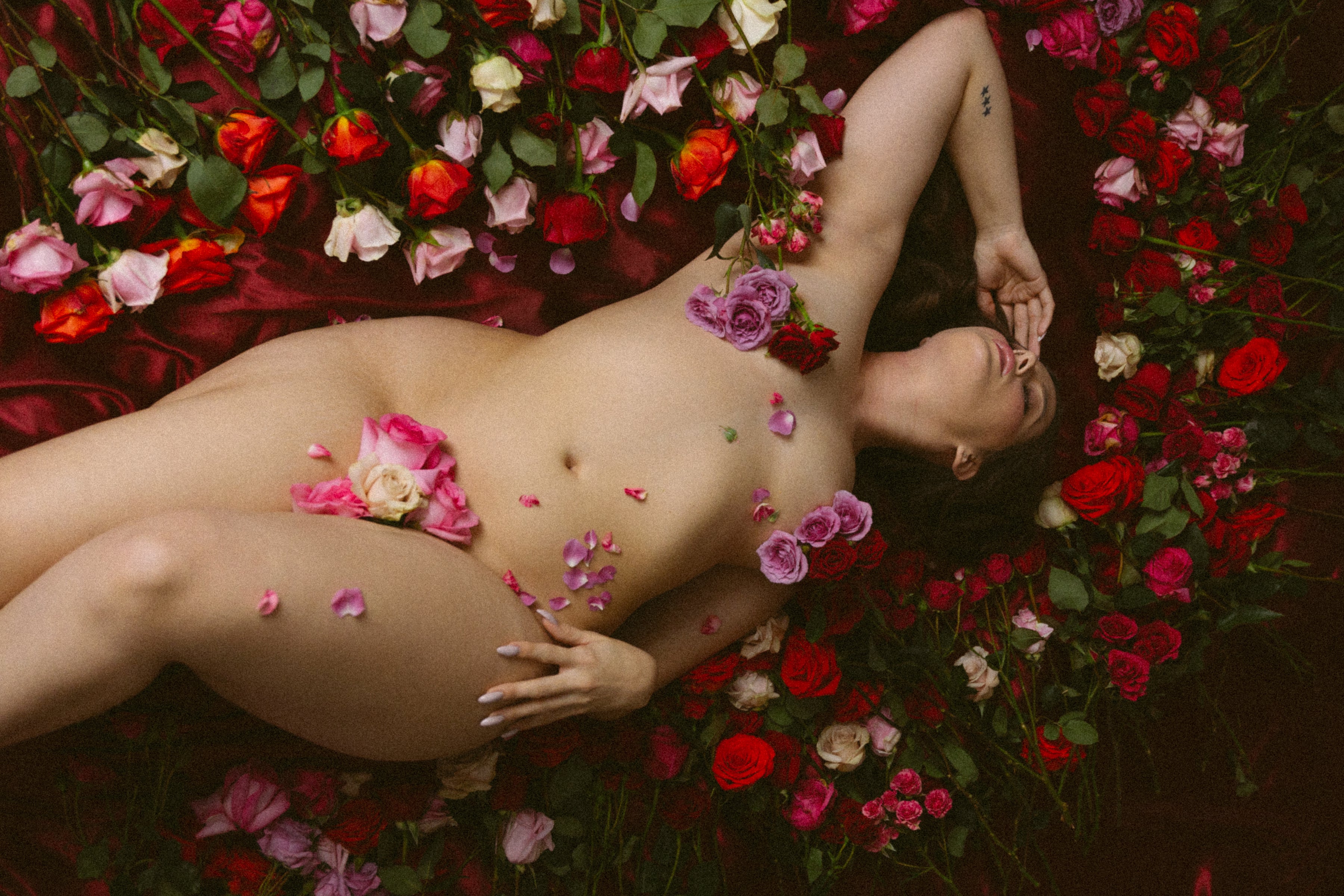 Editorial erotic photography — model surrounded by roses celebrating sensuality and desire at nympho life, photo by Bralettes and Brunch